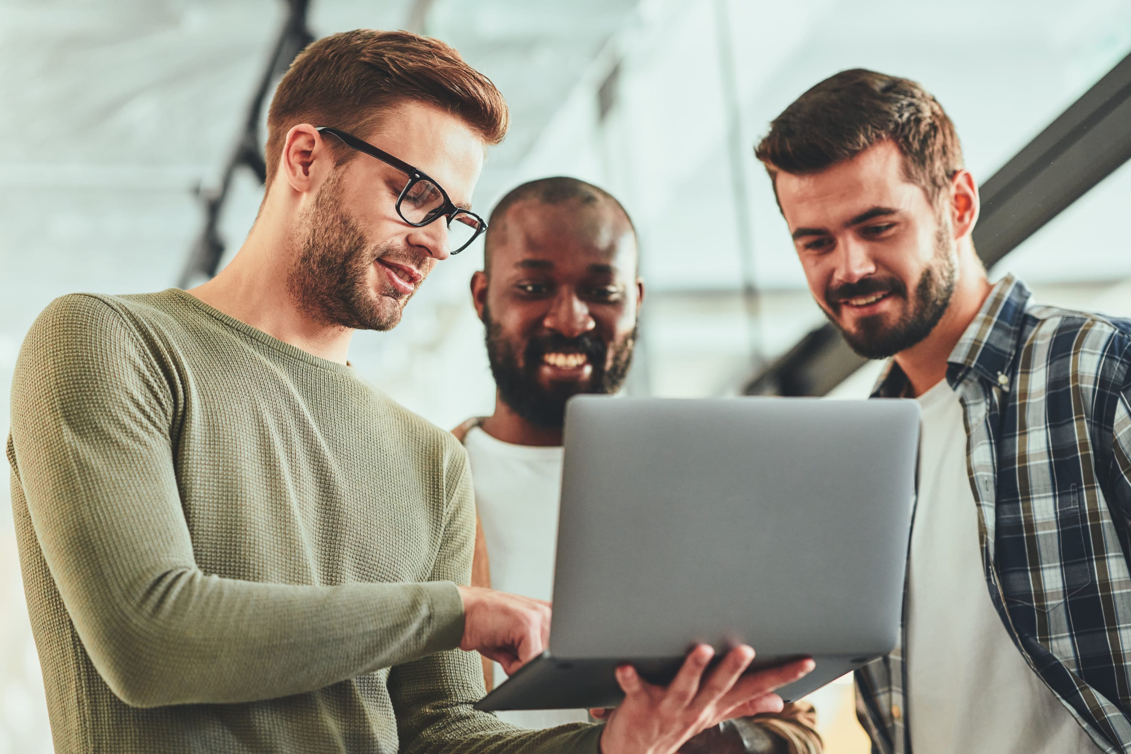 Scatto frontale di tre colleghi che discutono davanti a un laptop