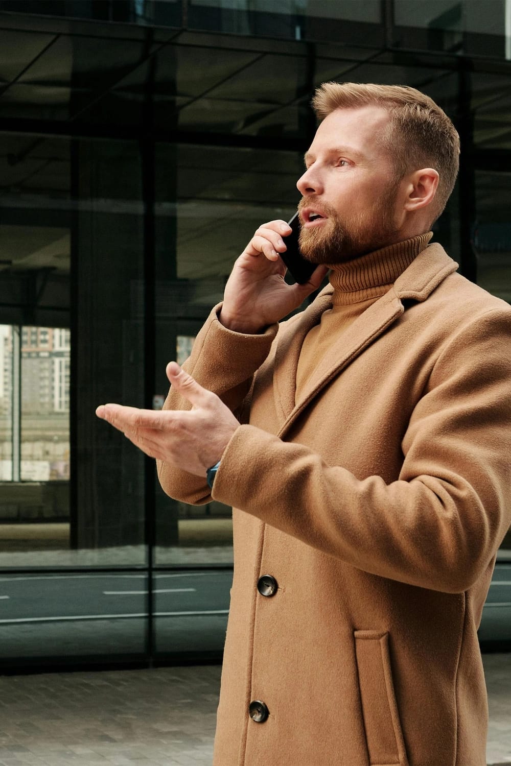 Ragazzo mentre parla al telefono all'esterno di un edificio.
