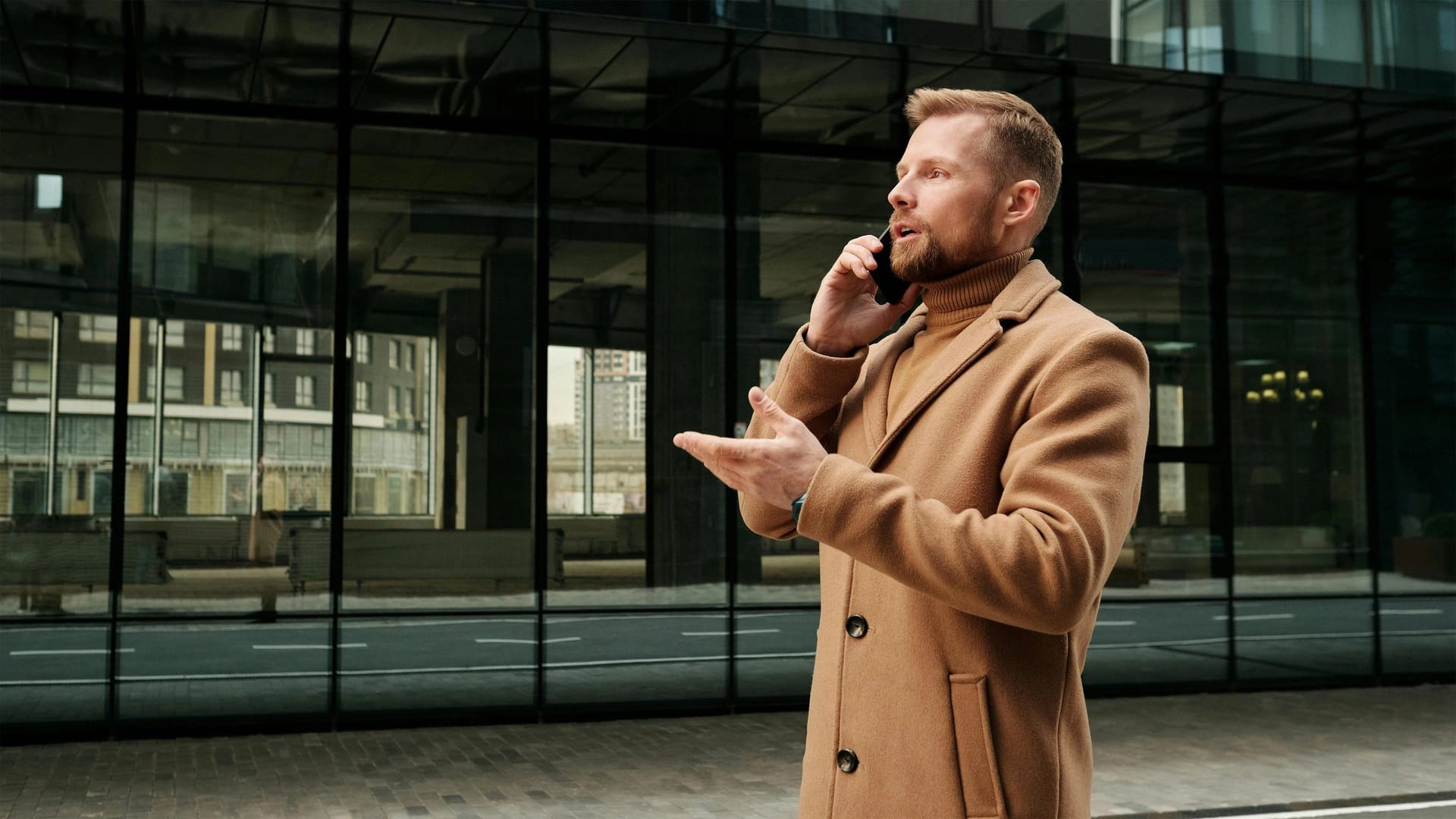 Ragazzo mentre parla al telefono all'esterno di un edificio.