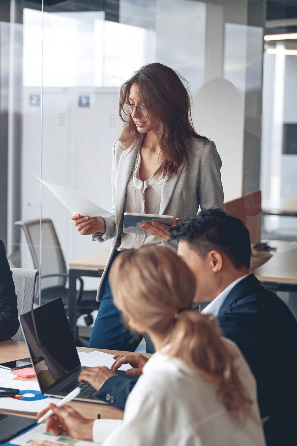 Alcuni colleghi mentre discutono tra loro. Una tra loro tieni dei fogli di carta in mano
