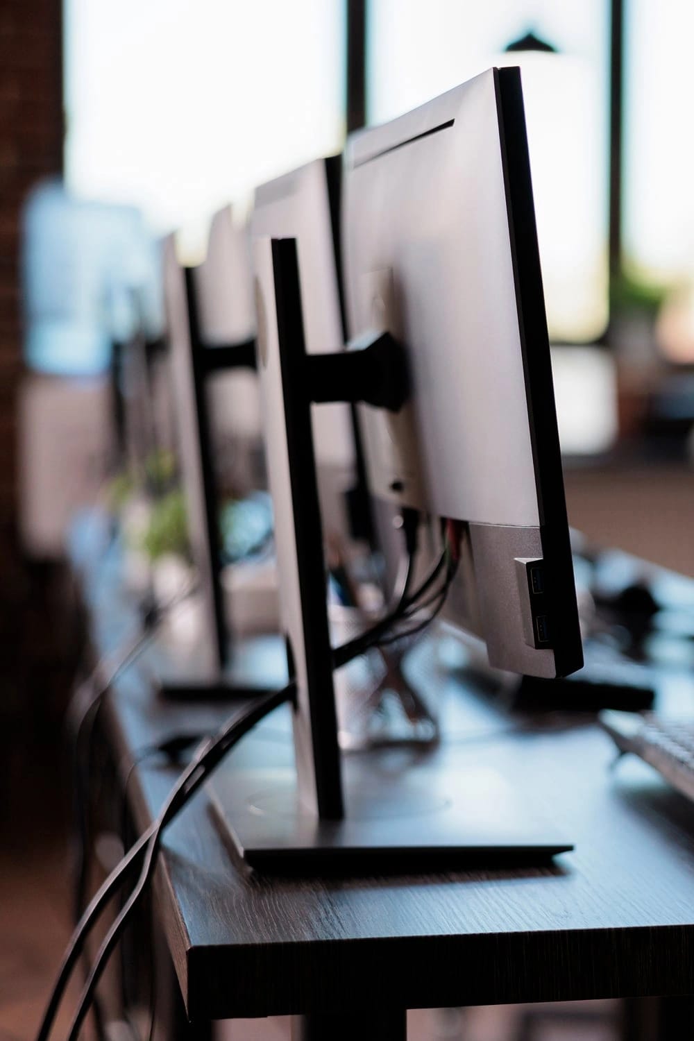 Primo piano del fianco di una scrivania con diversi monitor