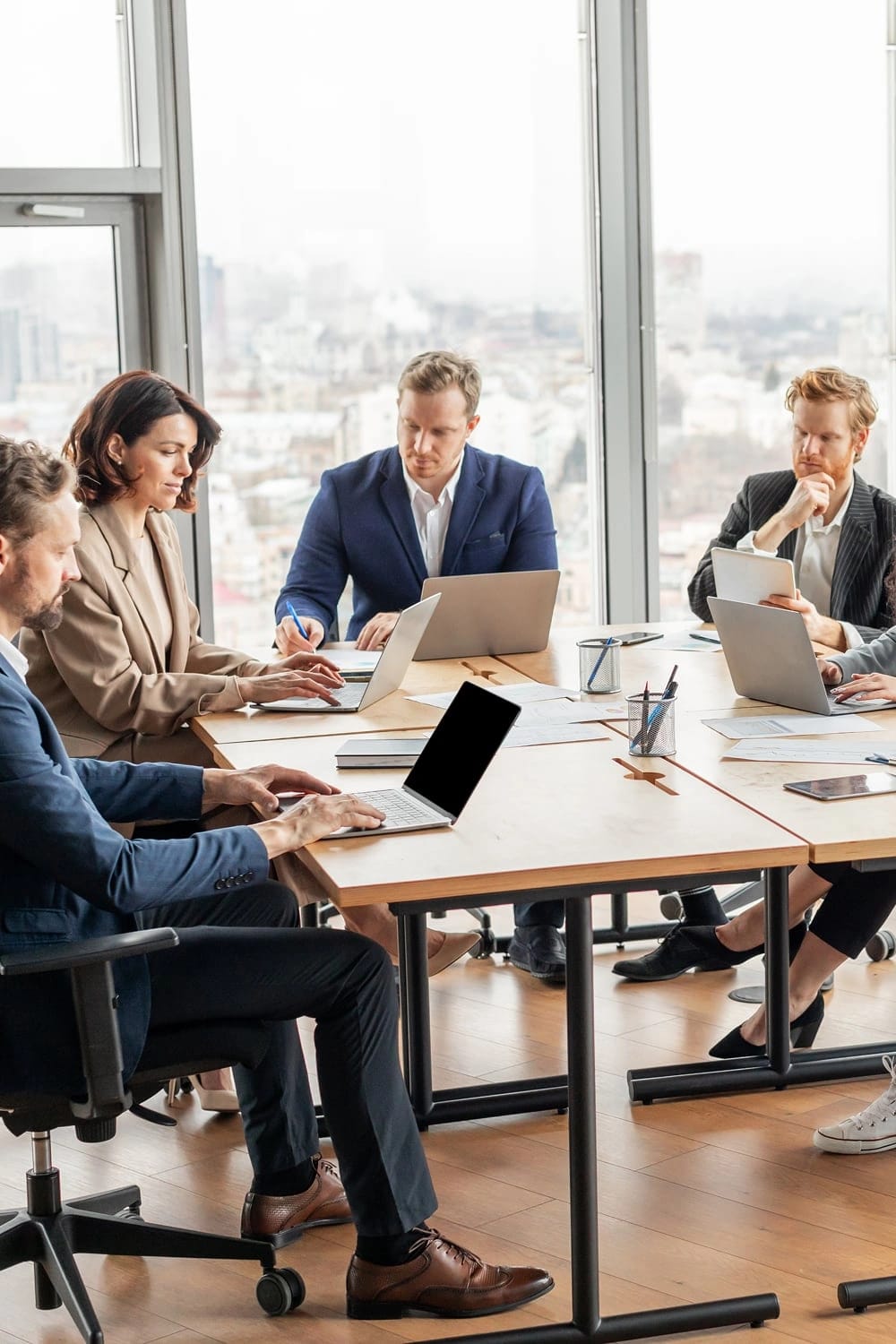 Cinque persone sedute in un sala riunioni discutono tra loro